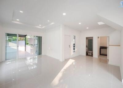 Spacious and bright modern living room with glossy tiled flooring, large windows, and direct access to outdoor area