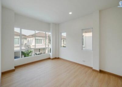 Spacious and well-lit empty bedroom with large windows and hardwood floors