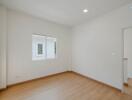 Bright and empty bedroom with wooden floor