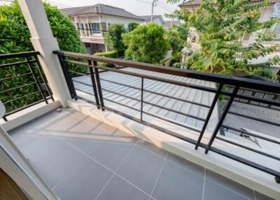 Spacious balcony with privacy fencing and greenery