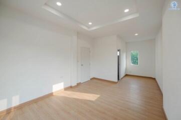 Spacious and brightly lit empty bedroom with wooden flooring