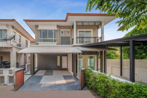 Modern two-story house with a carport and landscaped garden