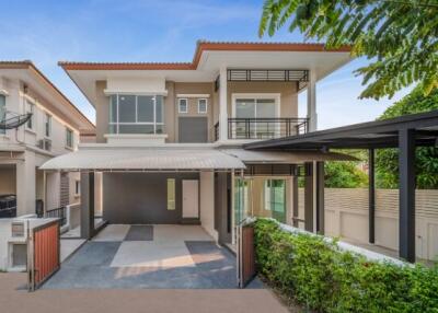 Modern two-story house with a carport and landscaped garden