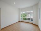 Spacious and well-lit empty bedroom with large windows and clean white walls