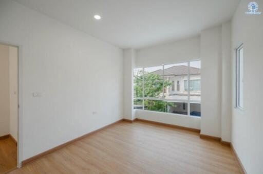 Spacious and well-lit empty bedroom with large windows and clean white walls