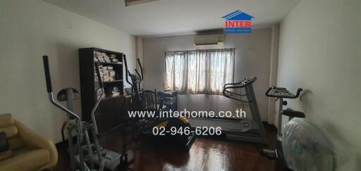 Spacious home gym room with various fitness equipment and large windows