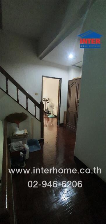 Spacious hallway in residential home with staircase and wooden accents