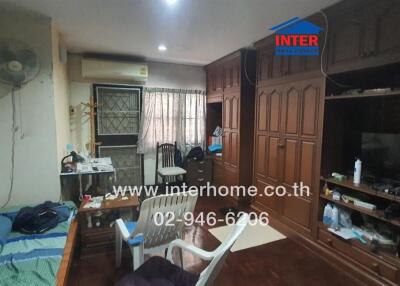 Spacious bedroom with wooden furniture and air conditioning unit