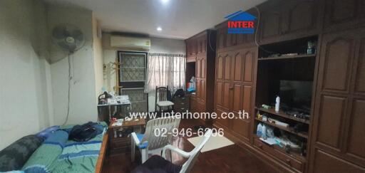 Spacious bedroom with wooden furniture and air conditioning unit