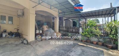 Exterior view of a house showcasing the carport and side garden