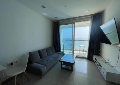 Spacious living room with ocean view, large windows, and modern furnishings