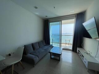 Spacious living room with ocean view, large windows, and modern furnishings