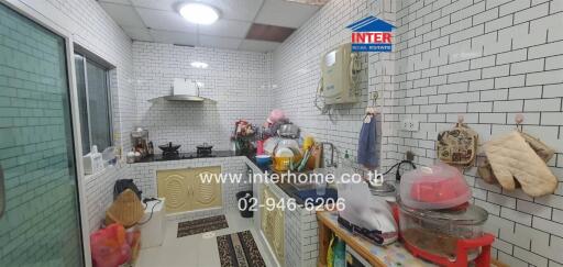 Compact fully equipped kitchen with white subway tiles and modern appliances