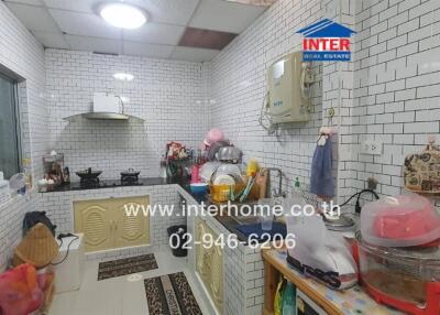 Compact fully equipped kitchen with white subway tiles and modern appliances