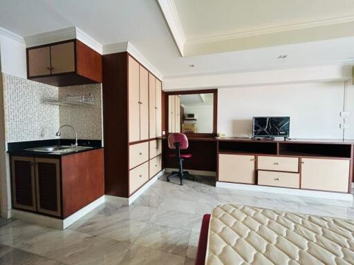 Modern kitchen with integrated workspace featuring marble flooring, wooden cabinets, and a cooking range