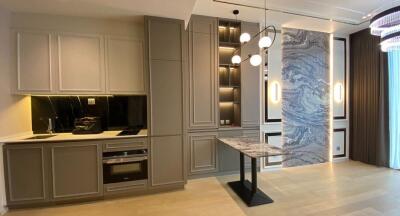 Modern kitchen with grey cabinetry, marble features, and elegant lighting