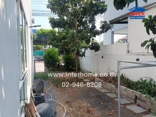 Spacious outdoor area of a residential home with greenery and potential for landscaping