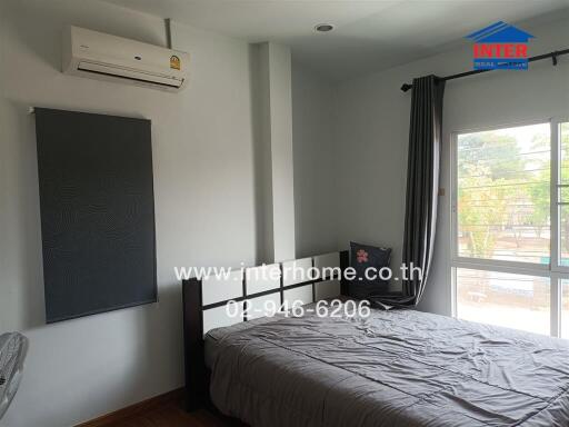 Spacious bedroom with natural light and modern air conditioning unit
