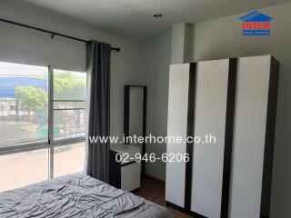 Spacious bedroom with large window and wardrobe
