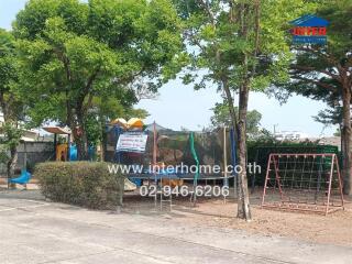 Community playground and sitting area with trees and exercise equipment