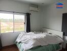 Cozy bedroom with large window and air conditioning unit