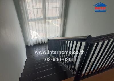 View of a stylish staircase in a modern home with natural light from windows