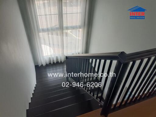 View of a stylish staircase in a modern home with natural light from windows