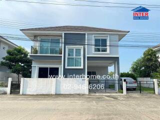 Modern two-story house with blue accents and a balcony