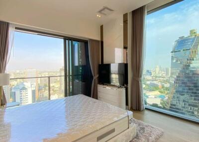 Modern bedroom with city skyline view through large windows