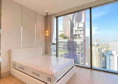 Modern bedroom with large window view of the city