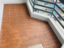 Small balcony with terracotta tiled flooring and railing