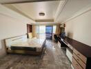 Spacious bedroom with marble flooring, large bed, and balcony access