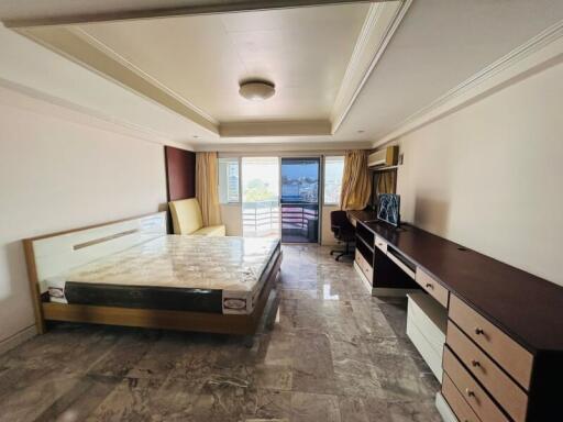 Spacious bedroom with marble flooring, large bed, and balcony access