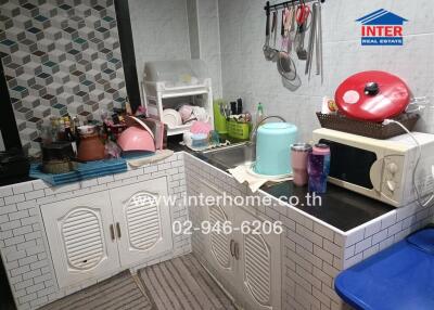 Compact kitchen with various appliances and utensils