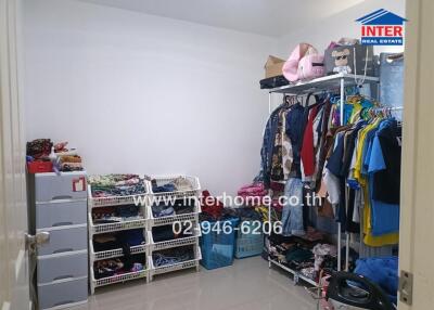 cluttered bedroom with extensive wardrobe and storage units