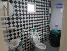 Compact bathroom with black and white patterned tiles and modern fixtures