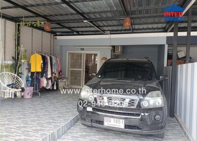 Spacious covered garage with a car and household items