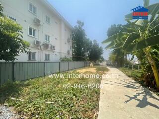 Exterior view of a residential building with surrounding green space