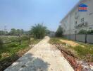 Pathway leading to modern apartment complex surrounded by foliage