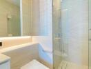 Modern bathroom with glass shower and marble tiles