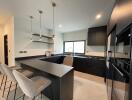 Modern spacious kitchen with black cabinetry and breakfast bar