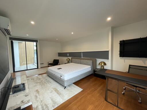 Spacious modern bedroom with large bed and desk area