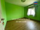 Bright bedroom with vibrant green walls and wooden flooring