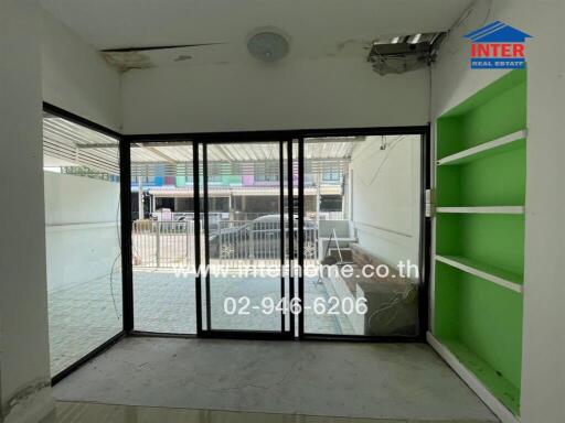 Empty room with large glass sliding doors opening to the front porch