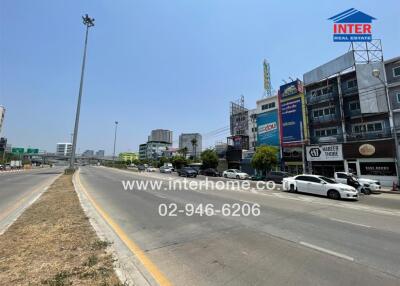Urban highway with commercial buildings and clear blue sky