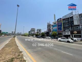 Urban highway with commercial buildings and clear blue sky