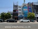 commercial building exterior with cars parked and signage