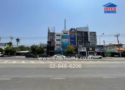 Urban commercial building exterior with visible real estate signage