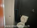 Compact bathroom with visible toilet and mirror