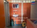 Compact bathroom with basic amenities and storage area